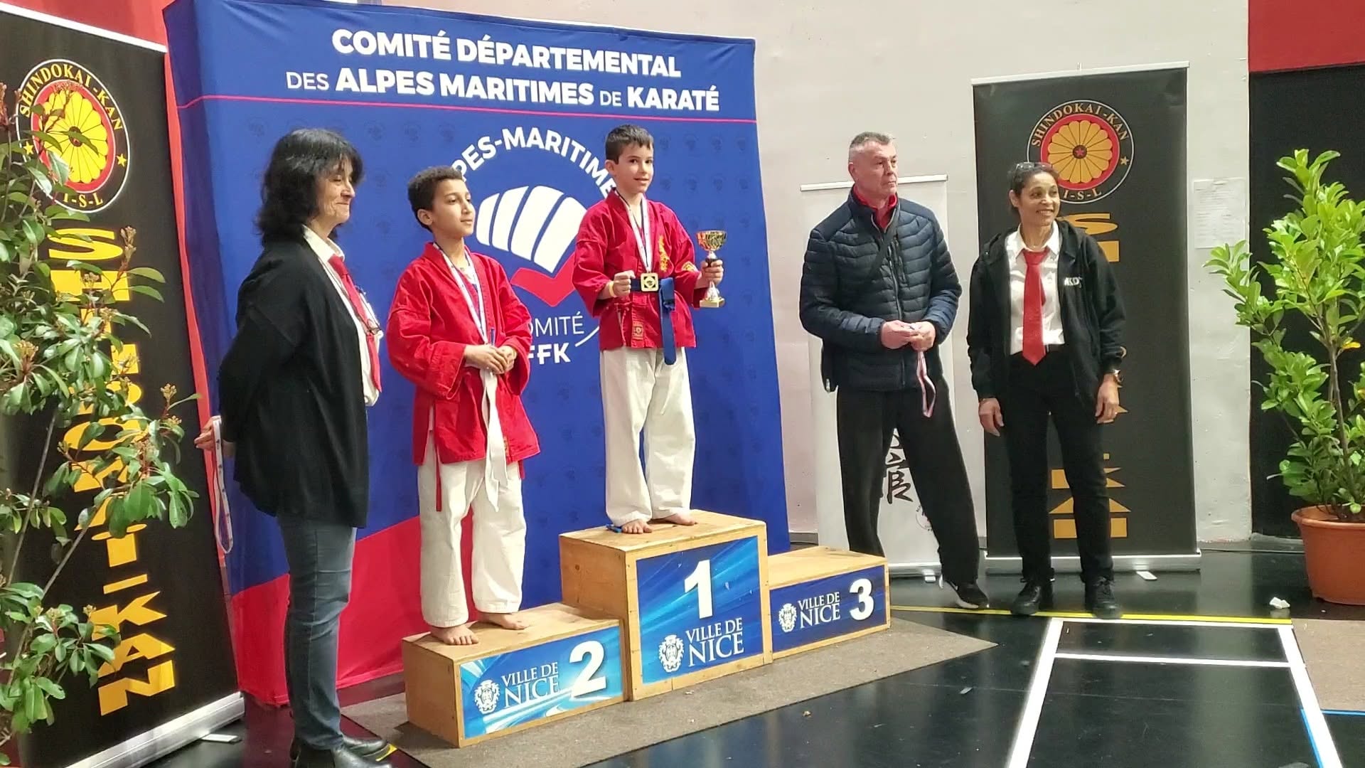 Deux jeunes pratiquants en tenue rouge sur un podium de Shindokaï.