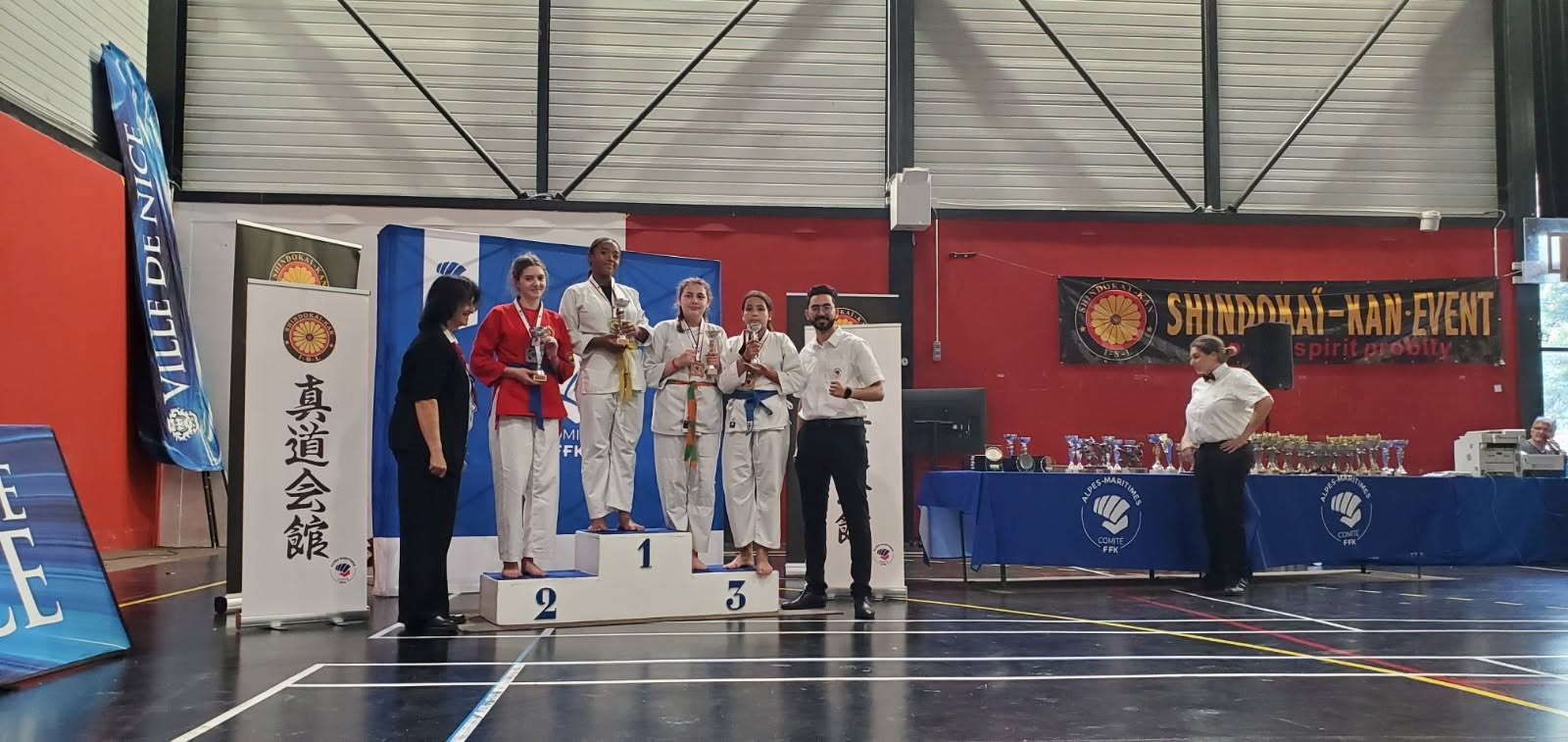 Pratiquantes réunies sur un podium avec leurs récompenses.