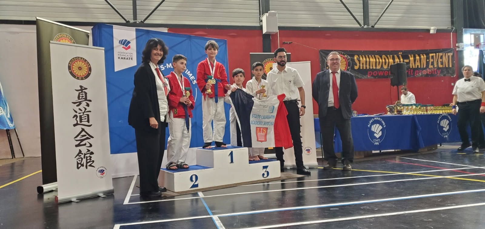 Jeunes médaillés sur un podium, accompagnés des encadrants.